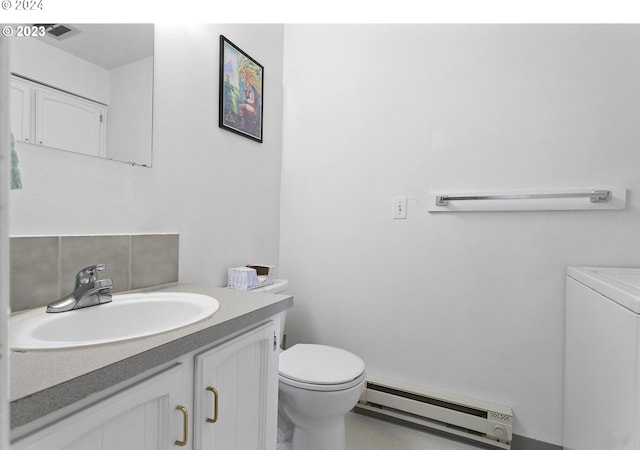 bathroom with washer / clothes dryer, toilet, vanity, decorative backsplash, and a baseboard radiator