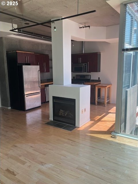 1410 SW 11th Ave Unit 402, Portland, OR 97201 - kitchen with freestanding refrigerator, range, light wood finished floors, and plenty of natural light