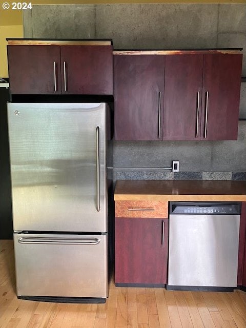 1410 SW 11th Ave Unit 402, Portland, OR 97201 - kitchen with light wood-type flooring, dark countertops, and stainless steel appliances