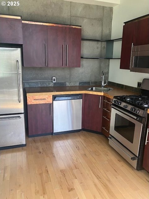 1410 SW 11th Ave Unit 402, Portland, OR 97201 - kitchen with stainless steel appliances, dark countertops, and light wood-type flooring