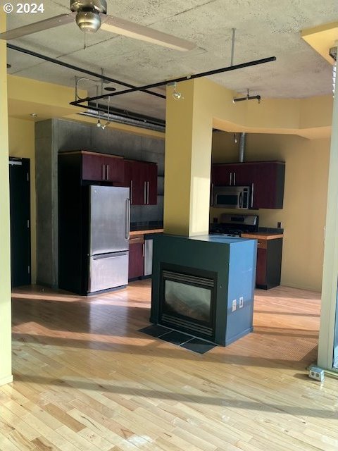 kitchen with stainless steel appliances, light wood-type flooring, and ceiling fan