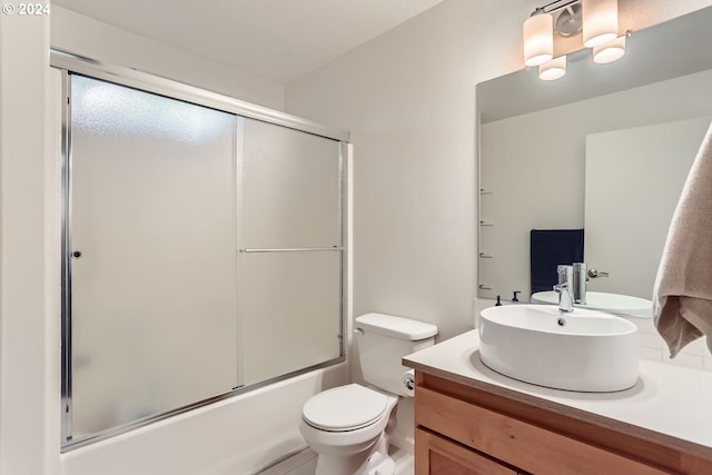 full bathroom with vanity, enclosed tub / shower combo, and toilet