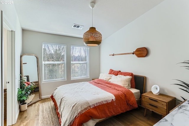 bedroom with wood-type flooring and lofted ceiling