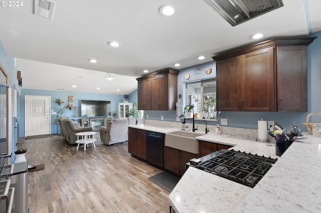 kitchen with light stone countertops, sink, black dishwasher, lofted ceiling, and light wood-type flooring