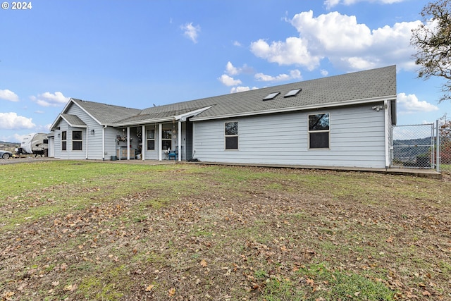 back of house featuring a lawn and a patio