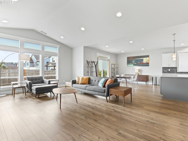 living room with vaulted ceiling and light wood-type flooring