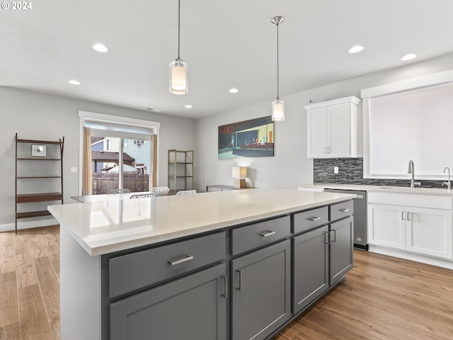 kitchen featuring sink, white cabinetry, gray cabinetry, hanging light fixtures, and a center island