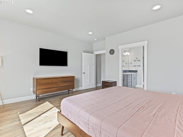 bedroom featuring light hardwood / wood-style flooring and ensuite bathroom