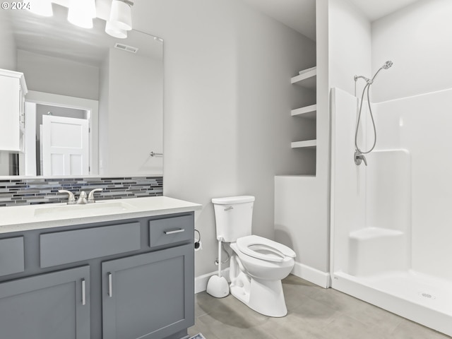 bathroom featuring vanity, decorative backsplash, toilet, and a shower