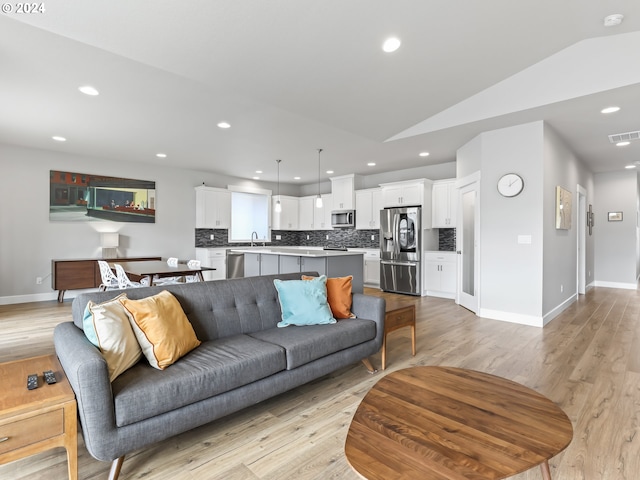 living room featuring vaulted ceiling and light wood-type flooring