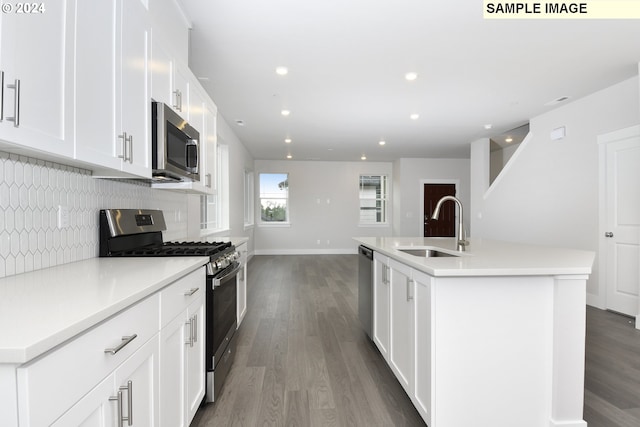 kitchen featuring appliances with stainless steel finishes, hardwood / wood-style floors, a kitchen island with sink, and sink