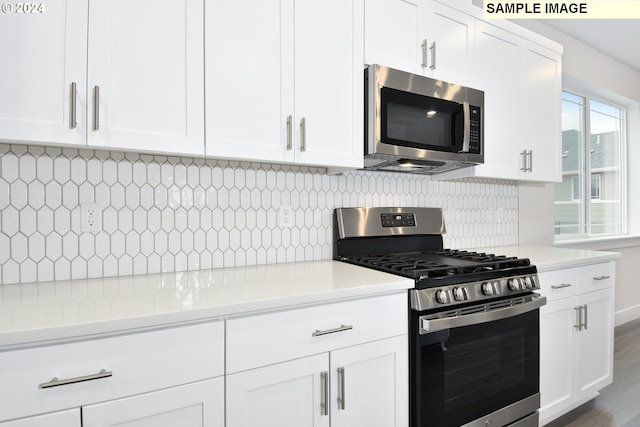 kitchen with stainless steel appliances, dark wood-type flooring, tasteful backsplash, and white cabinetry