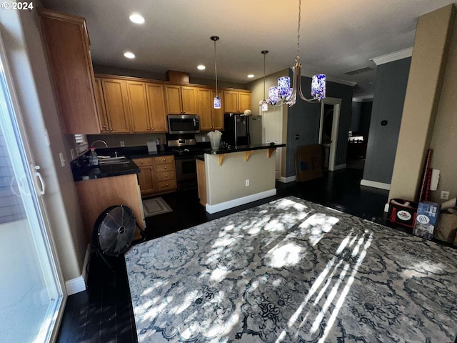 kitchen with a center island, a kitchen breakfast bar, stainless steel appliances, decorative light fixtures, and crown molding