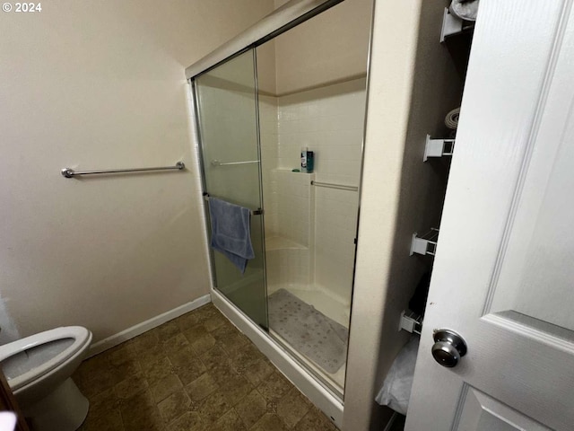 bathroom featuring toilet and an enclosed shower