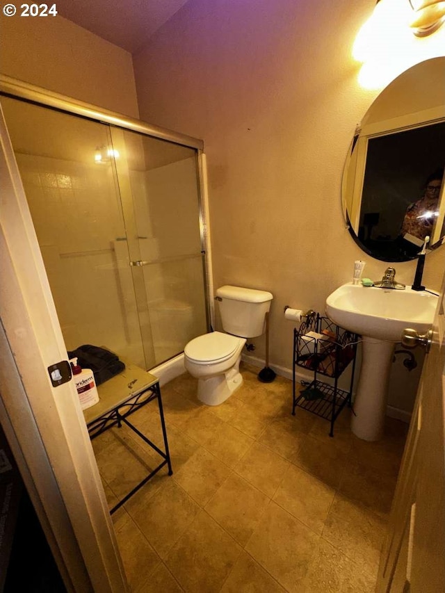 bathroom with a shower with shower door and toilet