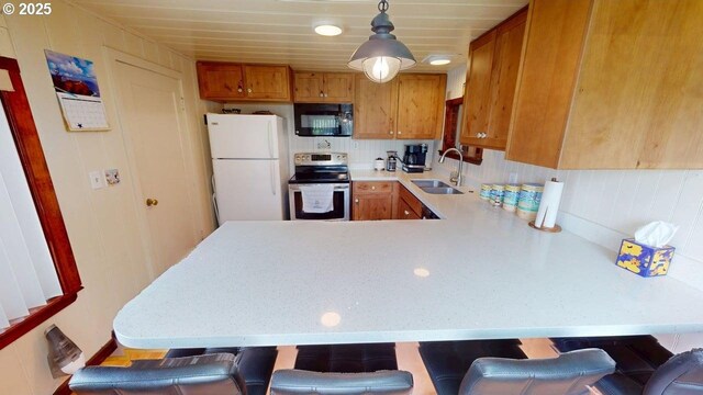 94142 4th St, Gold Beach, OR 97444 - kitchen featuring black microwave, stainless steel electric range, freestanding refrigerator, a sink, and light countertops