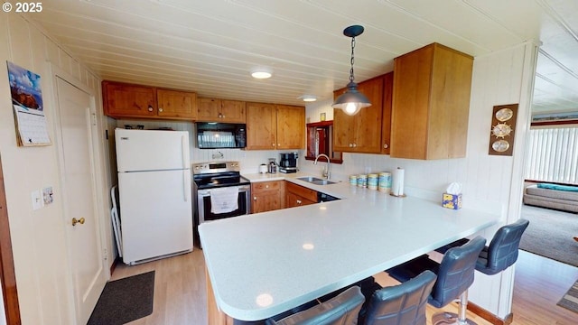 94142 4th St, Gold Beach, OR 97444 - kitchen with black microwave, freestanding refrigerator, stainless steel range with electric stovetop, a sink, and light wood-style flooring