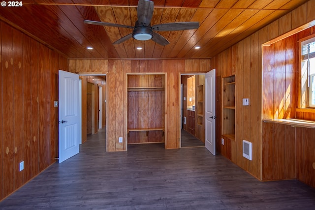 unfurnished bedroom featuring wooden ceiling, visible vents, dark wood-style flooring, and wood walls