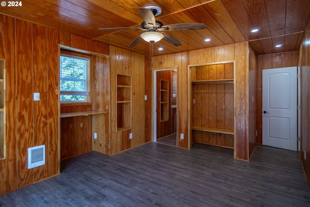 interior space with wooden walls, visible vents, wood ceiling, ceiling fan, and dark wood-type flooring