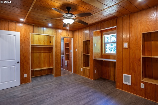 empty room with wood ceiling, dark wood finished floors, wooden walls, and ceiling fan