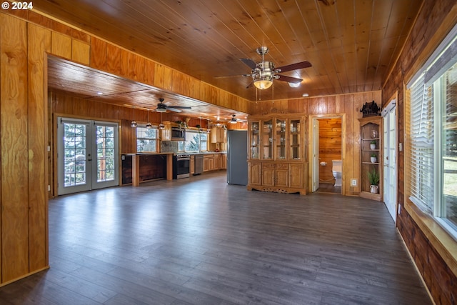 unfurnished living room featuring dark wood-type flooring, wooden ceiling, and wooden walls