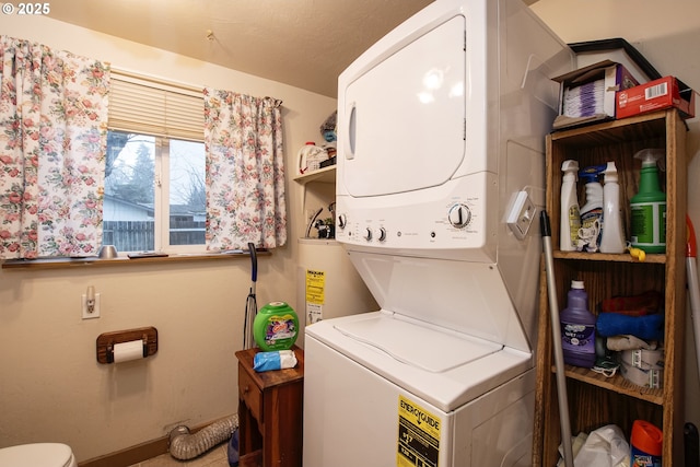 clothes washing area with stacked washer and dryer and water heater