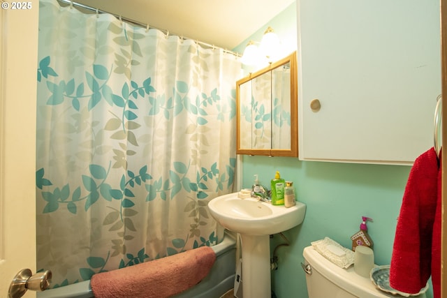 bathroom featuring shower / bath combo with shower curtain and toilet