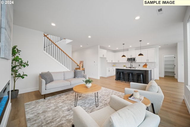 living room with light wood-type flooring and sink