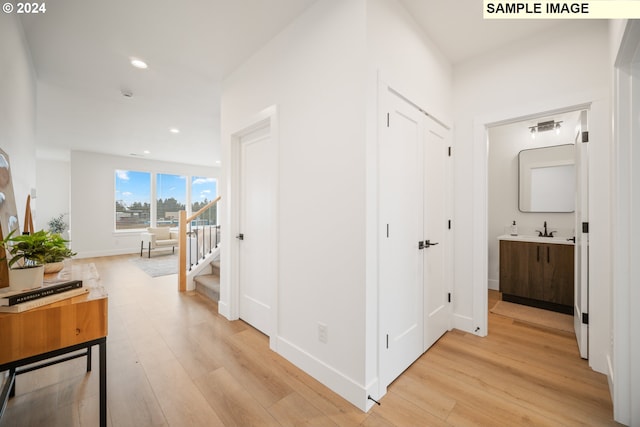 hallway with sink and light hardwood / wood-style floors