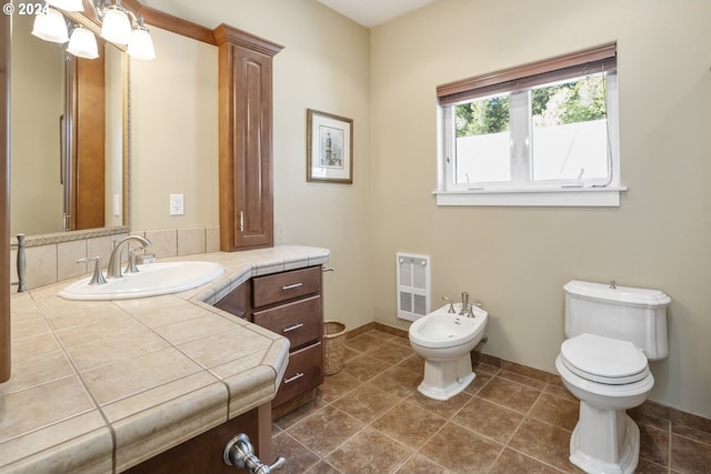 bathroom featuring heating unit, a bidet, tile patterned floors, vanity, and toilet