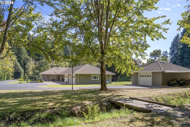 single story home featuring a garage and a front lawn