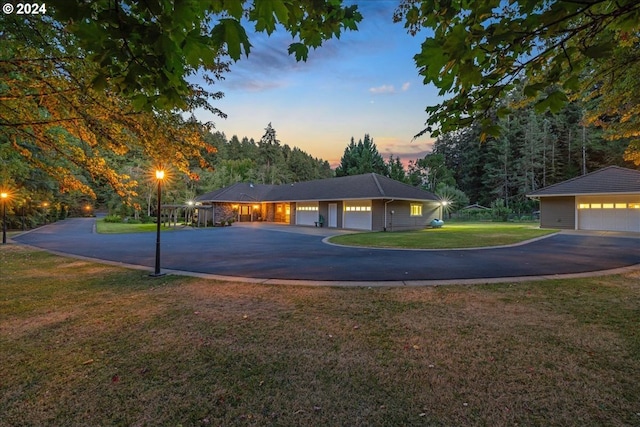 ranch-style house featuring a garage and a yard