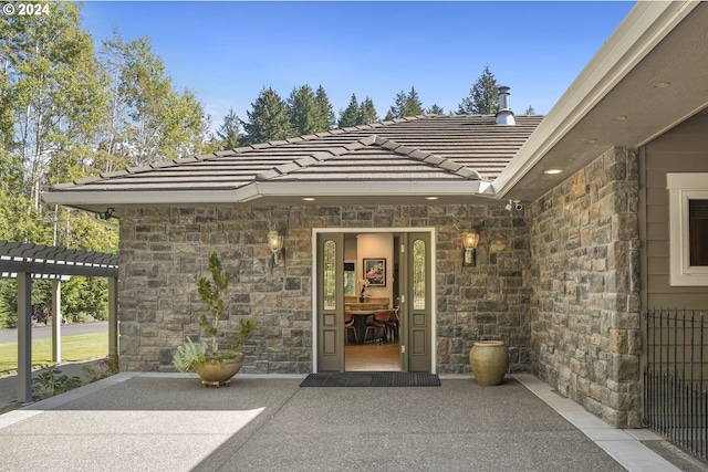 view of exterior entry with a patio area