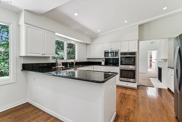 2585 Dellwood Dr, Lake Oswego, OR 97034 - kitchen featuring stainless steel appliances, a peninsula, white cabinetry, and wood finished floors