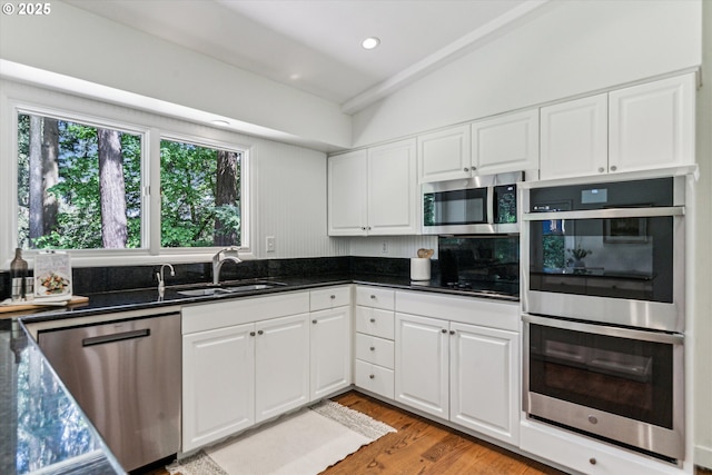 2585 Dellwood Dr, Lake Oswego, OR 97034 - kitchen with white cabinets, stainless steel appliances, a sink, and light wood-type flooring