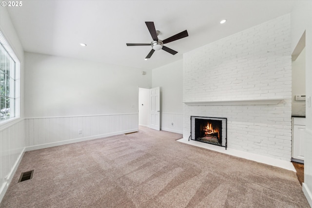 2585 Dellwood Dr, Lake Oswego, OR 97034 - unfurnished living room with visible vents, a ceiling fan, a fireplace, a wainscoted wall, and carpet flooring
