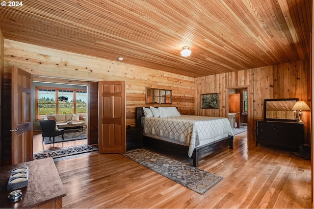 bedroom with light hardwood / wood-style floors, wooden ceiling, and wood walls