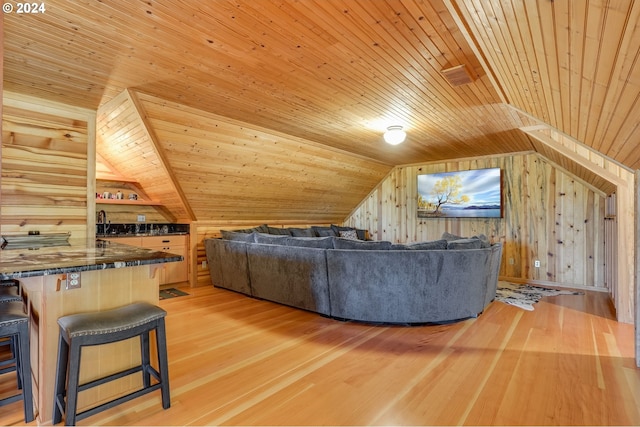 unfurnished living room featuring wood walls, light hardwood / wood-style flooring, and wooden ceiling