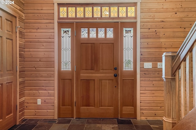 foyer featuring wooden walls