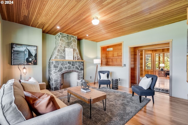 living room featuring a fireplace, wood ceiling, and wood-type flooring