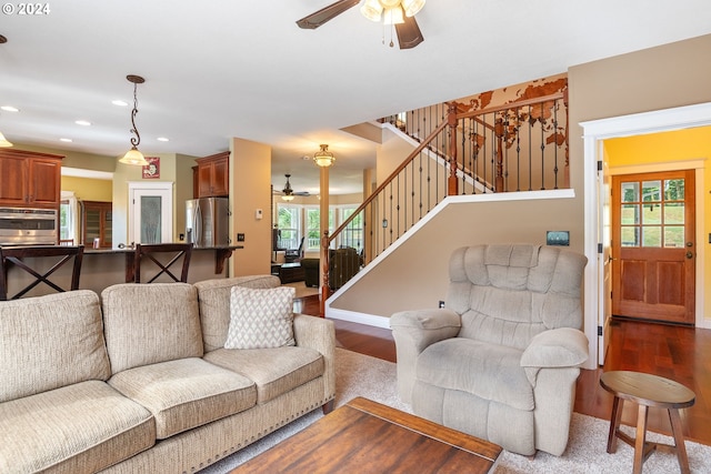 living room featuring wood-type flooring and ceiling fan