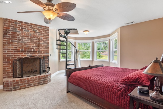 bedroom with a brick fireplace, carpet floors, and ceiling fan