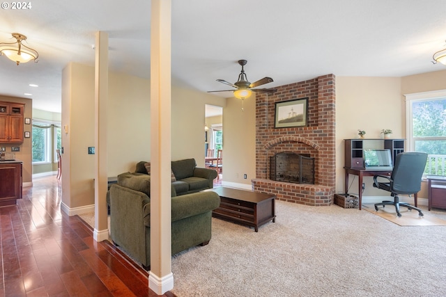 living room featuring a wealth of natural light, a brick fireplace, hardwood / wood-style floors, and ceiling fan