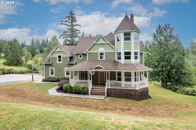 victorian house with a front lawn and a porch