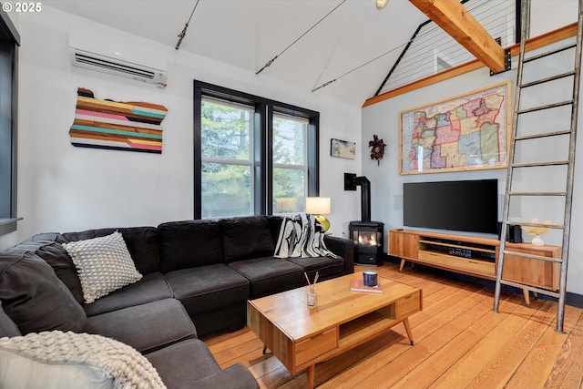 living room featuring vaulted ceiling with beams, light wood-type flooring, a wall mounted air conditioner, and a wood stove