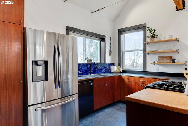 kitchen with black dishwasher, stainless steel fridge with ice dispenser, lofted ceiling, gas range, and a sink