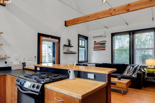 kitchen with a wall unit AC, lofted ceiling with beams, brown cabinets, open floor plan, and black gas stove