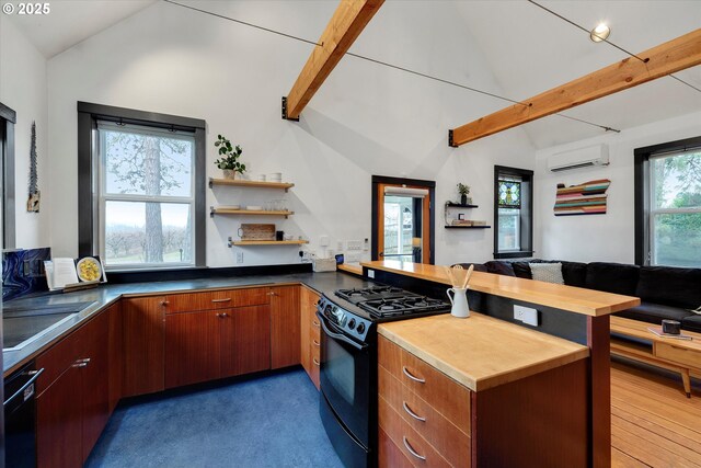 kitchen featuring vaulted ceiling with beams, open floor plan, a wall mounted air conditioner, a peninsula, and black appliances