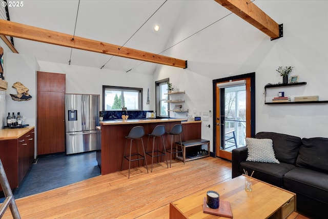 living room with light wood-type flooring, high vaulted ceiling, and beamed ceiling