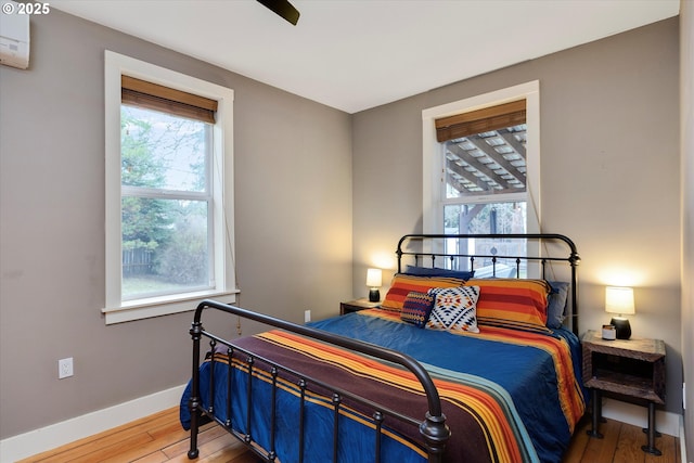 bedroom with baseboards and hardwood / wood-style flooring